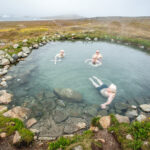 People enjoying a hot spring pool in Greenland, Arctic. Greenland travel. Greenland cruise.