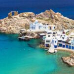 Blue waters surrounding Greek Island with blue and white Greek Styled building. Sea cruise Greece