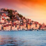 Town of Sibenik in Croatia viewed from Mediterranean sea with sunset colors over the red roofed buildings. Cathedral in Palma Spain. Mediterranean sea cruise