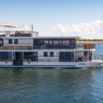 African Dream river cruise ship lake Kariba. Small 2 deck ship with sun deck roof cruising in Lake Kariba with bank of lake in background.