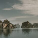 Halong bay at the end of The Red River. The bay has towering limestone islands topped with rainforests all set in the waters of the ocean. River cruise in Asia.