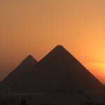 Sunset and silhouettes of the Pyramids of Egypt. Itinerary stop of Nile River cruise
